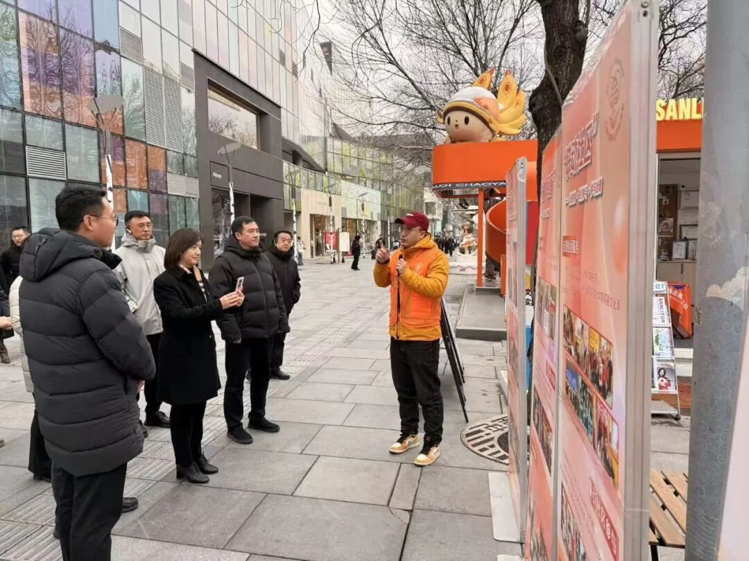志愿者在街区服务展板前讲解服务内容